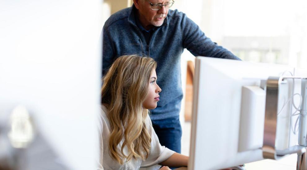 Professor showing student something on the computer